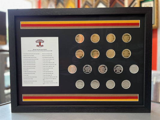 Framed display of gold and silver medical achievement medals with repurposed ribbons, black matboard, and modern black Larson Juhl shadowbox.