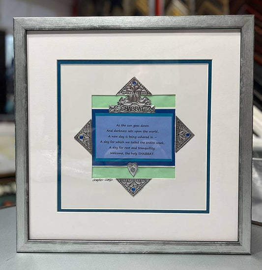 Shabbat artwork framed with silver and black Arquati moulding, white mat, blue-green liner, and Museum Glass.