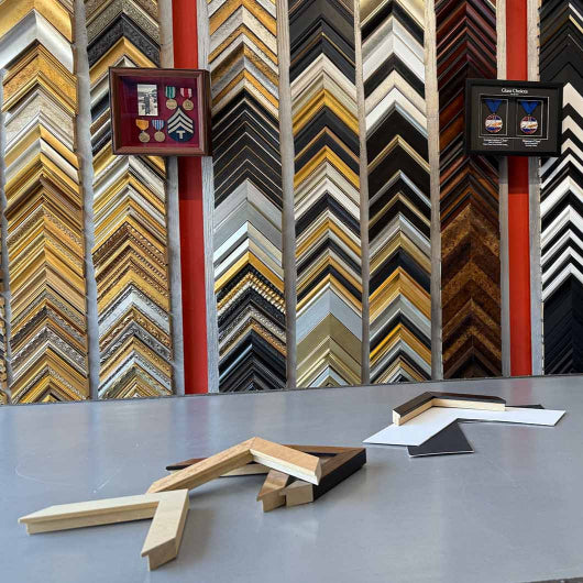 Display of various wooden picture frames with different designs on a wall.