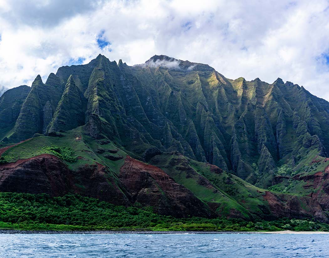 Mountainous landscape with greenery and a body of water below